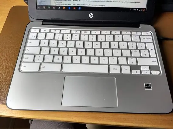 Un Chromebook HP gris ouvert, vu de dessus, avec son clavier blanc.