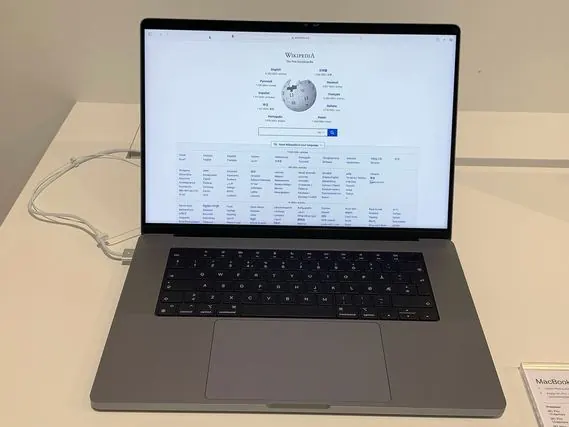 Un MacBook Pro de 16 pouces ouvert sur une table, écran allumé.